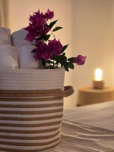 a vase with purple flowers sitting on top of a bed at Il Mandorlo in Santa Teresa Gallura