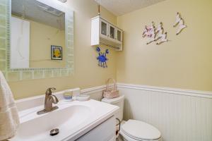 une salle de bain avec un lavabo, des toilettes et un miroir dans l'établissement Waterfront Nags Head Townhome with Amenity Access!, à Nags Head 16 autres photos