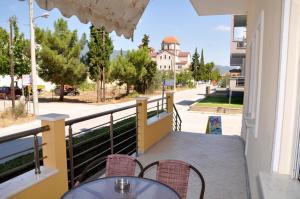 a balcony with tables and chairs and a view of a street at Themis Rooms in Nea Vrasna