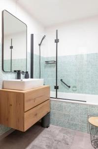 a bathroom with a sink and a tub and a mirror at Ferienwohnung Bergzeit in Pfronten