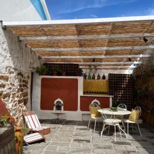 a patio with a table and chairs and a grill at Obidos Rural Chic House in Usseira