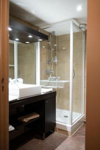 a bathroom with a shower and a white sink at Résidence Le Grand Tétras- SPA THERMAL INCLUS in Ax-les-Thermes