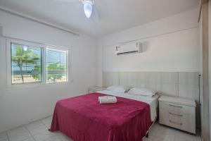 a white bedroom with a bed with a red blanket at GRJA011- Frente ao mar | Localização ideal com 3Q in Balneário Camboriú