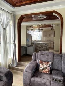 ein Wohnzimmer mit Sofa und eine Küche in der Unterkunft Comfortable house in Solai in Nakuru