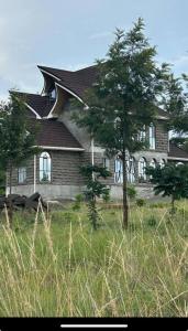 ein Haus mit zwei Bäumen davor in der Unterkunft Comfortable house in Solai in Nakuru