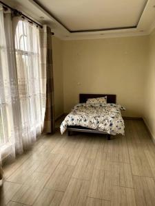 ein Schlafzimmer mit einem Bett in einem Zimmer mit Fenstern in der Unterkunft Comfortable house in Solai in Nakuru