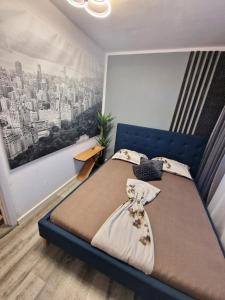 a bedroom with a blue bed with a painting on the wall at Azzur Studios Aparthotel in Constanţa