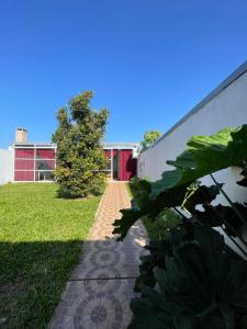 a brick walkway in front of a red building at Alojamiento Itaembe Guazu in Villa Dolores +8 photos