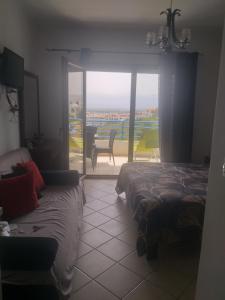 a bedroom with two beds and a view of a patio at Appart-Hotel Cabodream beach in Tétouan
