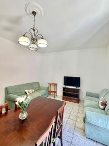a living room with a table and two couches at Nura's - Casa Girasole in Alghero