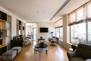 a living room with chairs and tables and a tv at Hotel Conde de Agueda in Águeda