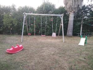 a playground with a swing set in a yard at THE PALM ROOMs in Preveza