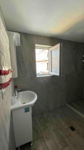 a small bathroom with a sink and a window at Studio Kikki Sozopol in Sozopol