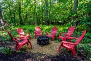 a group of red chairs around a fire pit at Owls Retreat in McHenry