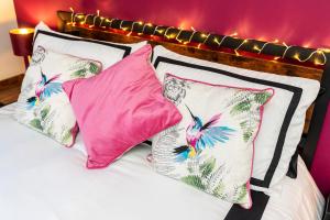 a bed with four pink and white pillows at Doncaster Lakeside Paradise Place in Doncaster