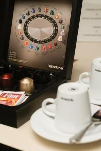a desk with a monitor and a cup and aucer at Sol Ipanema Hotel in Rio de Janeiro