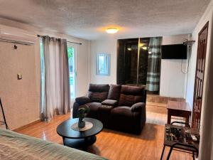a living room with a couch and a table at Carambola Rooms in Las Delicias