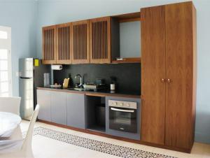 a kitchen with wooden cabinets and a stove at ConSentido Tamarindo in Mérida