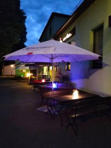 a couple of tables with umbrellas in front of a building at Pension Gasthaus Schützenhaus in Waldenburg
