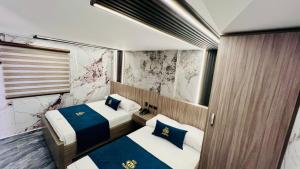 a small room with two beds and a window at Hotel Balmoral in Bucaramanga