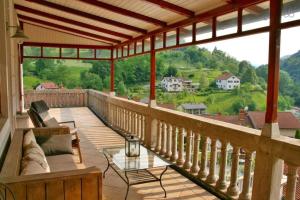 a porch with a couch and a glass table at Stylish Penthouse with large terrace in Most na Soči