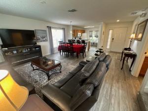 a living room with a leather couch and a table at Beautiful 3-Bedroom Pool Villa in Southern Dunes in Haines City