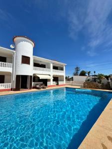 a swimming pool in front of a house at Apartment Tres Palmeras with pool in Vinarós