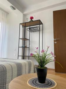 a room with a table with a vase with flowers on it at Heart of Prishtina Apartment in Pristina