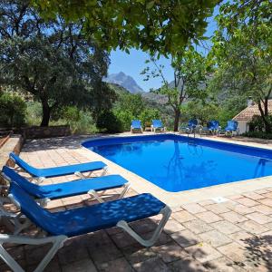 una piscina con due sedie a sdraio e una piscina di Cerro de la Cruz, increíbles vistas en el centro de Andalucía a Priego de Córdoba