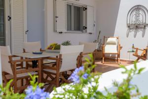 a patio with a wooden table and chairs at ALTHEA HOUSES in Alinda
