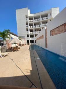 une piscine devant un immeuble dans l'établissement AMPARO RESORT, à Los Ayala