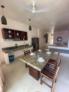 une cuisine avec une table, des chaises et un comptoir dans l'établissement AMPARO RESORT, à Los Ayala