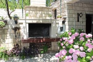 un camino in pietra in un cortile con fiori rosa di Apartments Sveti Anton a Orebić (Sabbioncello)