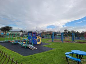 ein Spielplatz mit Rutsche in einem Park in der Unterkunft A beautiful 4 birth - 714 Unity Beach Holiday Resort Unity 2 pets stay free in Brean