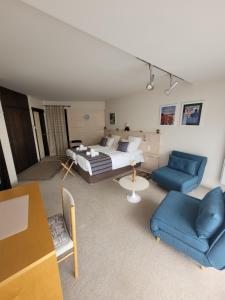 a living room with a bed and two blue chairs at villa deloro in Orbey +35 photos