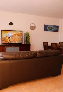 a living room with a couch and a flat screen tv at Casa Lara Fuerteventura in Corralejo