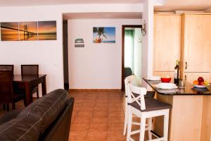 a kitchen and living room with a couch and a table at Casa Lara Fuerteventura in Corralejo