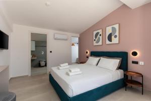 a bedroom with a large bed with a blue headboard at Plakias Seaside Residences - Dandelion in Plakias