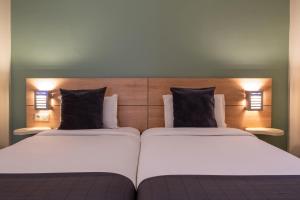 A bed or beds in a room at Manzil Hotel