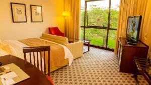 una habitación de hotel con una cama y un televisor en Phakalane Golf Estate Hotel & Convention Centre, en Gaborone