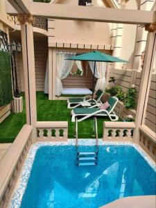 a swimming pool with an umbrella and a table and chairs at Magnifique villa avec piscine privée in Alger