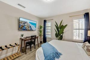 a bedroom with a bed and a desk and windows at Luxury Home, Heated Saltwater Pool, 5-Min to Beach in Seminole +74 photos