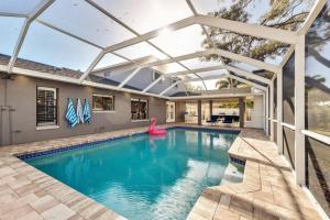 an indoor swimming pool with a pergola over it at Luxury Home, Heated Saltwater Pool, 5-Min to Beach in Seminole
