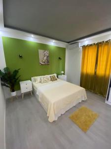 Un dormitorio con una cama grande y una pared verde. en Villa Verdi, en Biograd na Moru