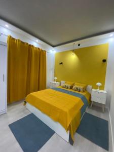 1 dormitorio con 1 cama grande y pared amarilla en Villa Verdi, en Biograd na Moru 4 fotos más