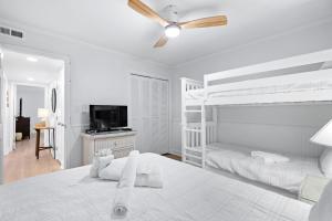 una camera da letto bianca con un letto e un ventilatore a soffitto di Sea Cabin Ocean View Unit 225 a Myrtle Beach Altre 32 foto