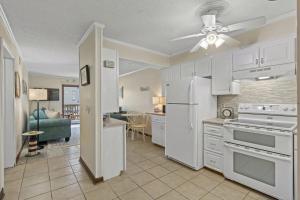 a kitchen with white appliances and a ceiling fan at Seafarer Oceanview Unit 107 in Myrtle Beach