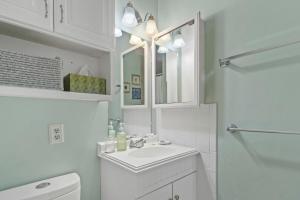 a white bathroom with a sink and a mirror at Seafarer Oceanview Unit 107 in Myrtle Beach +35 photos