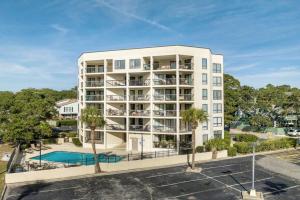 マートルビーチにあるCarol Bay Serene Ocean View Unit 202のプールと駐車場付きのアパートメントビル