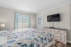 a bedroom with a bed and a flat screen tv at Chateau By the Sea Oceanfront Unit H2 in Myrtle Beach +27 photos